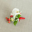 A delicately styled boutonniere rests on a softly textured, oatmeal-coloured linen background, the kind of natural fabric you might see on a rustic table in a South Croydon townhouse near Lloyd Park. At the heart of the piece sits a pristine white Phalaenopsis orchid, its broad petals opening like porcelain wings and revealing a warm throat flushed with creamy yellow and hints of soft orange. Around the orchid, tiny white baby's breath blooms cluster in airy clouds, their minute petals catching the gentle, even daylight and adding a soft halo of texture. Slender green stems and smooth, elliptical leaves in varied shades of fresh green are threaded through the arrangement, framing the white flowers and giving the design a quietly lush feel. Nestled close to the orchid is a compact spray of glossy, cherry-red berries, their rounded surfaces gleaming as if just polished, alongside a few paler green, immature buds that suggest new growth and freshness. The stems are gathered neatly at the base and wrapped in a rich red satin ribbon, tied into a small, precise knot with short tails that lie flat against the fabric, ready to be pinned to a lapel or dress. The composition feels intimate and carefully considered, ideal for a groom or guest arriving at a winter wedding in South Croydon, a Christmas service along Brighton Road, or a formal celebration where a single, beautifully crafted floral accent can quietly express elegance, romance, and attention to detail with every petal and berry.